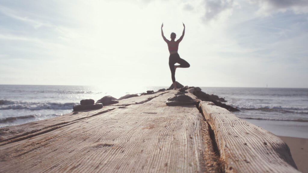 Man doing yoga on dock - Yoga resources