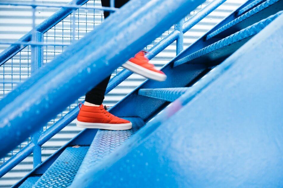 orange shoes walk up blue steps towards personal values