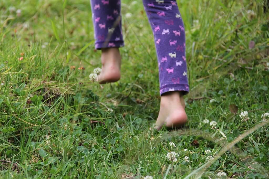 little girl walking in the grass